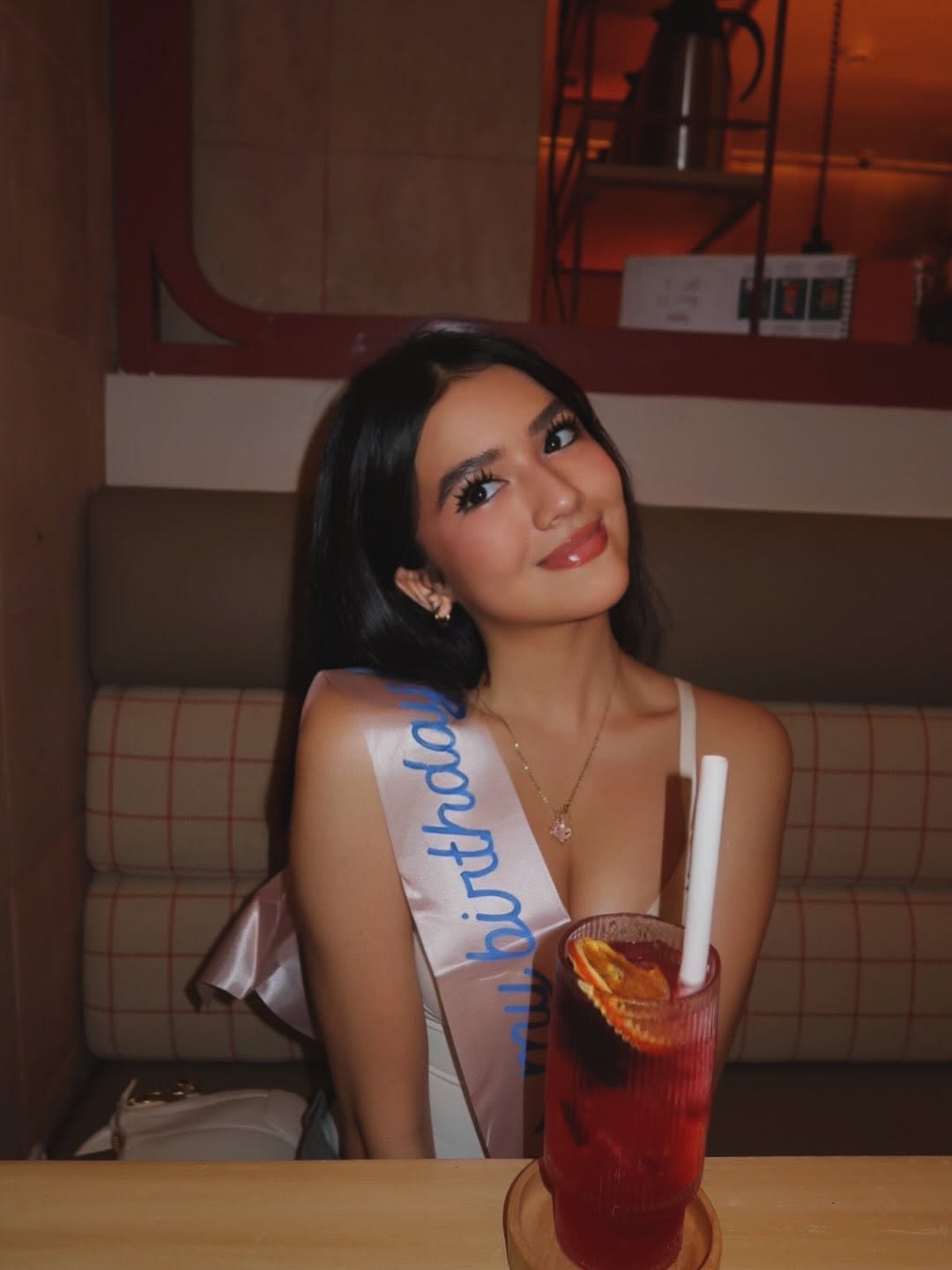 Sabrina Cuervo at a table with a pink Hello Kitty birthday cake and a gift bag