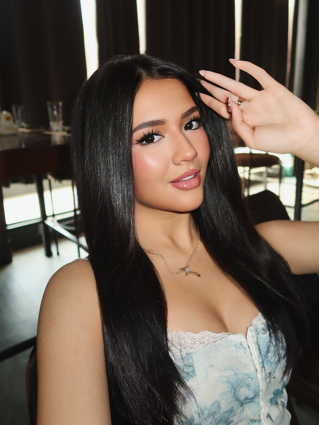 Close-up of Sabrina Cuervo with glossy dark hair and a black off-shoulder top