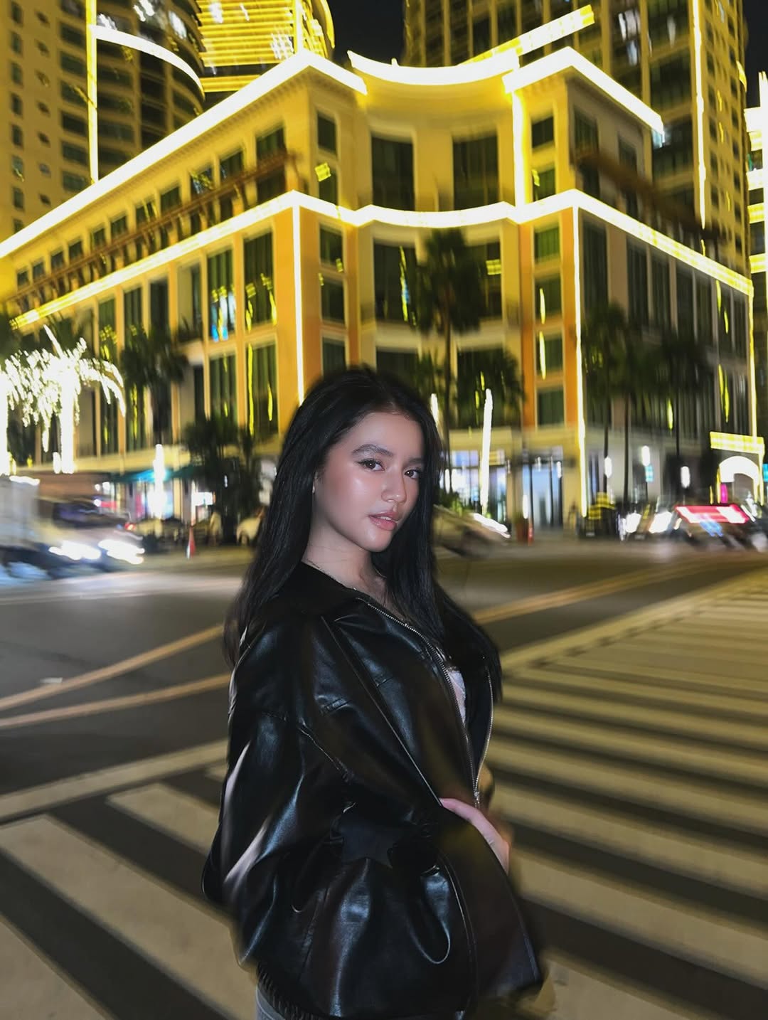 Sabrina Cuervo in a short black dress standing in a parking garage at night